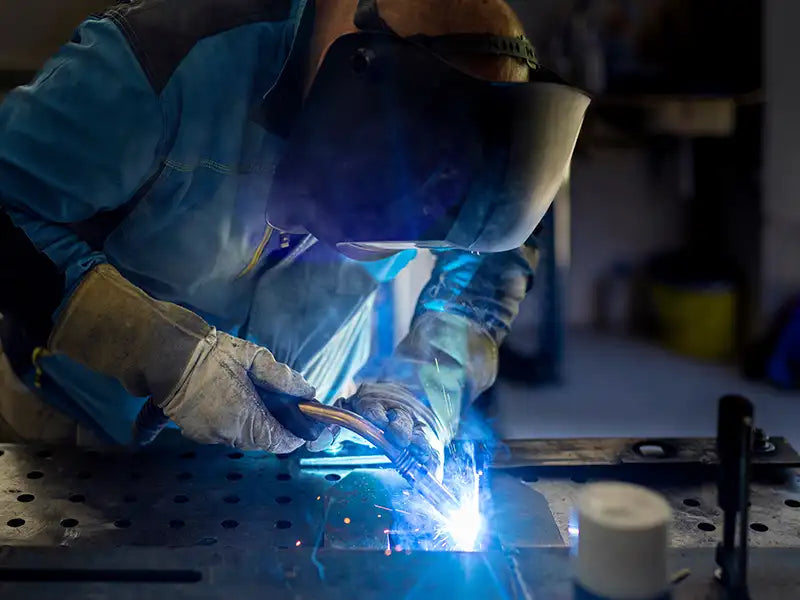 Ein Schweißer, der Aluminium am Schweißtisch schweißt