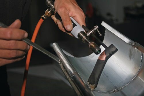 Weichlötbrenner in Anwendung mit Schlauchanschluss und Lötspitze am Metallwerkstück
